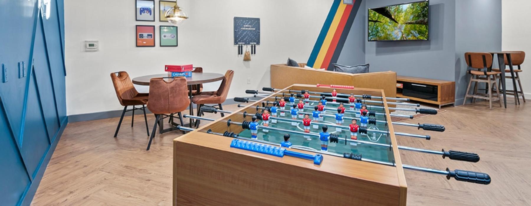 a room with a pool table and chairs and a tv on the wall