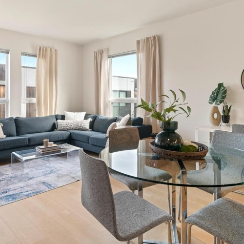 Wide open living areas flooded with natural light a living room with a blue couch and a round coffee table